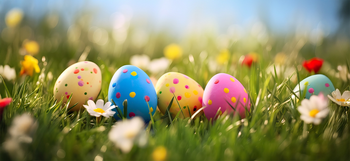 colorful polka dot easter eggs nestled in green spring grass with daisies and wildflowers easter celebration banner