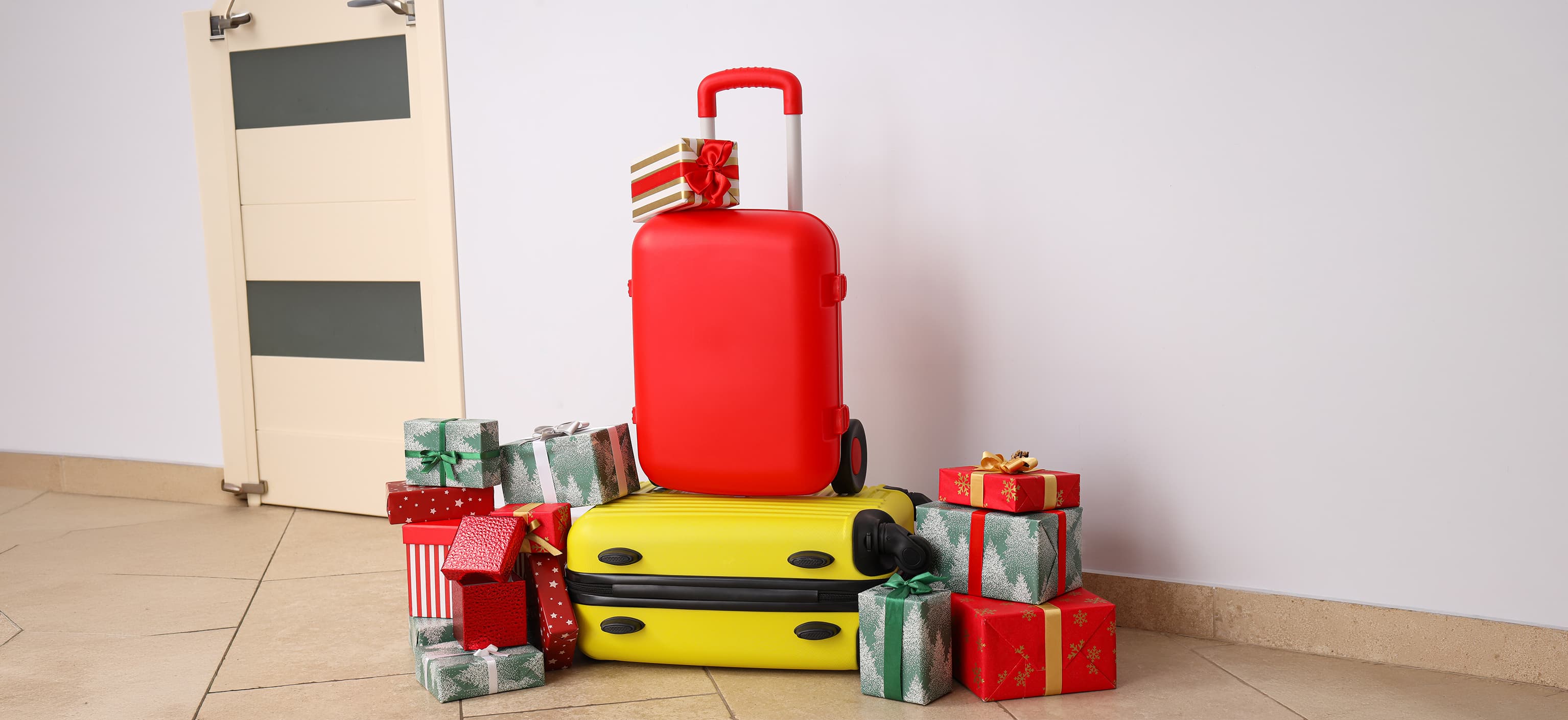 Curated travel gifts laid out next to a packed suitcase
