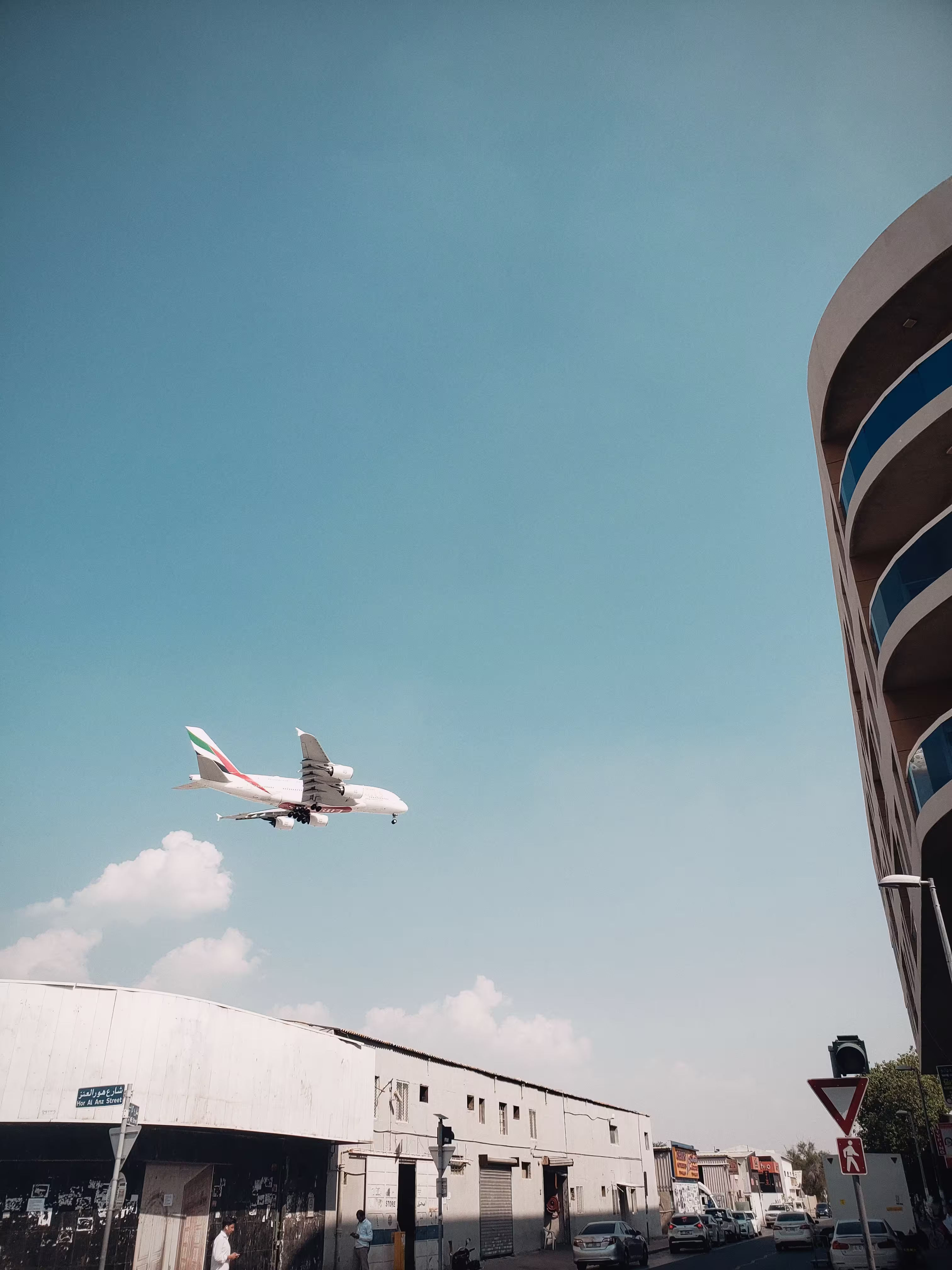 Commercial airplane flying over Dubai urban street