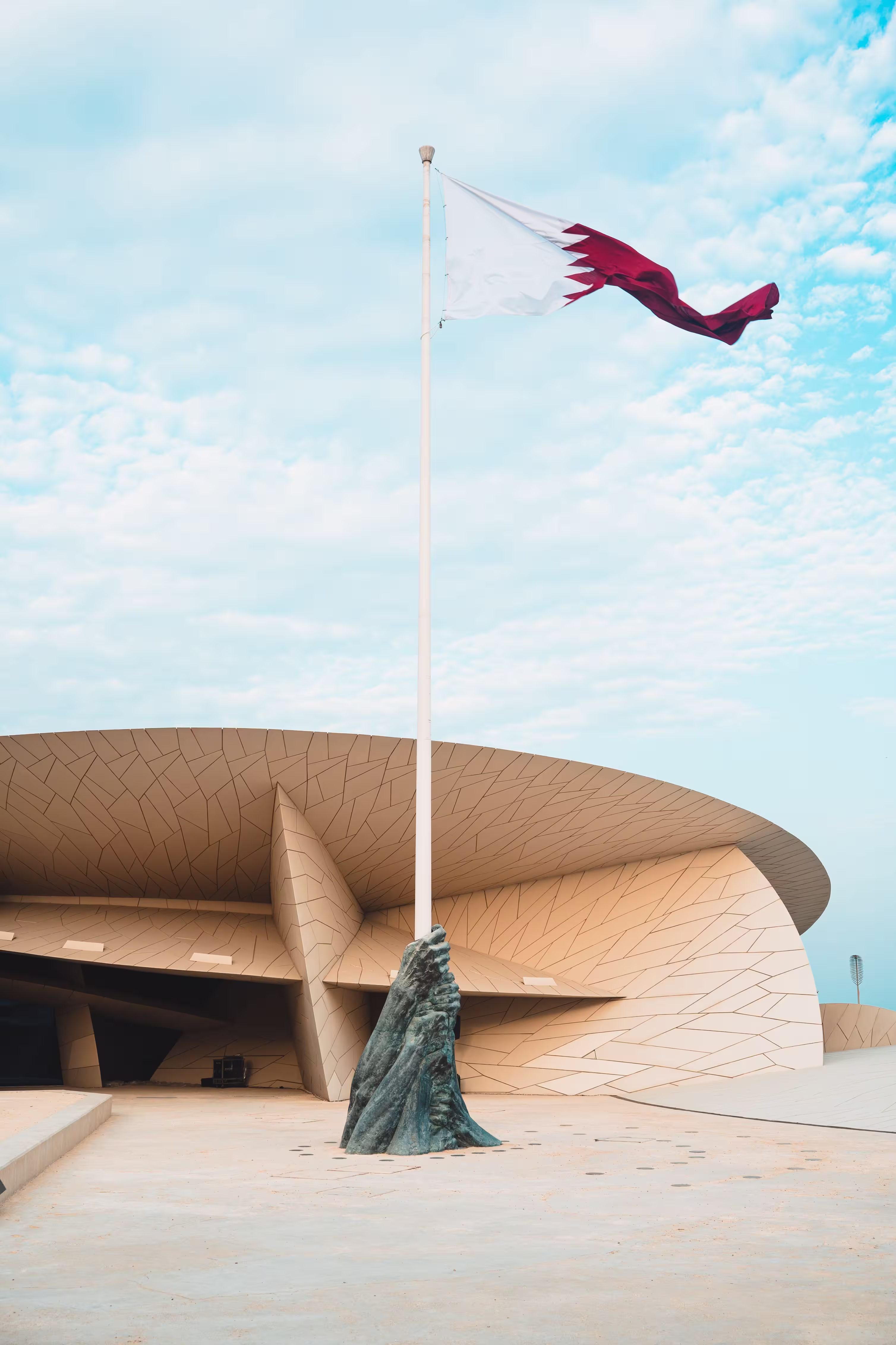 flag-of-qatar-swaying-by-the-wind-under-blue-sky