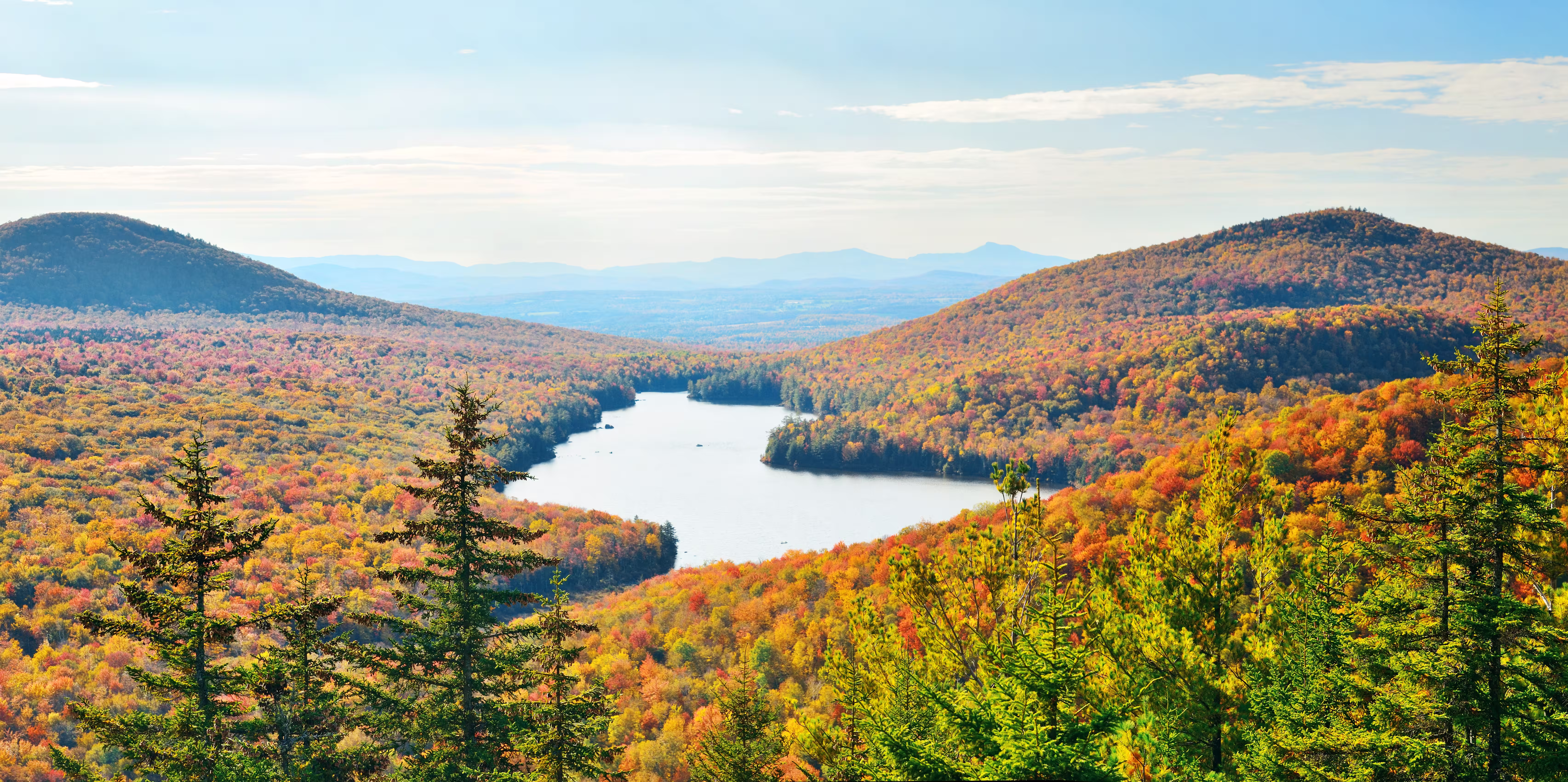 Lake surrounded by autumn foliage viewed from a mountaintop in Vermont's Green Mountains